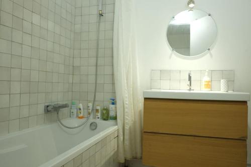 une salle de bain avec une baignoire, un lavabo et un miroir dans l'établissement Sunny apartment Garibaldi Port, Private parking, à Nice