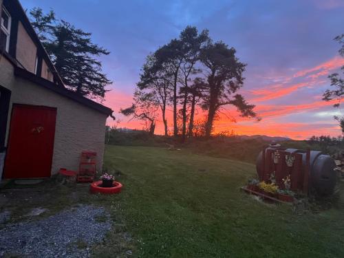 a sunset over a yard with a house and a field at Daffodil Lodge in Sligo