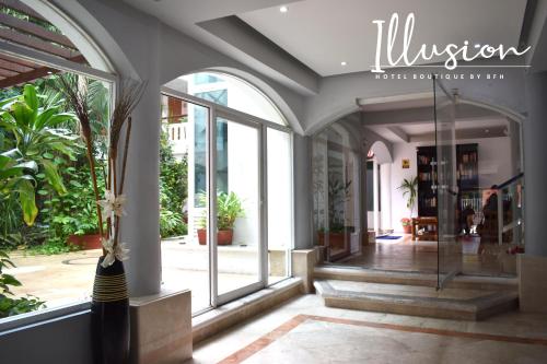 a lobby of a building with glass doors and plants at Illusion Boutique "Near Beach" in Playa del Carmen