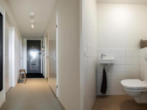 Un baño blanco con inodoro y lavabo. en Cottage in Wissenkerke near Nature Reserve, en Wissenkerke