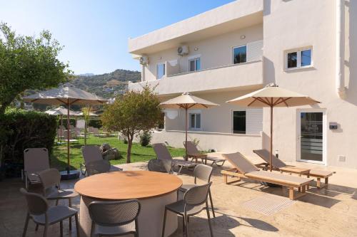 a patio with tables and chairs and umbrellas at Apollo Plakias in Plakias