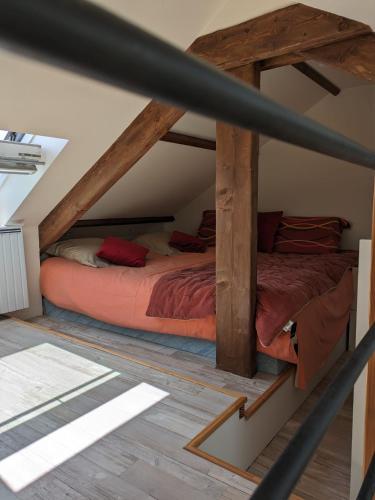 Cette chambre mansardée comprend 2 lits et des poutres apparentes. dans l'établissement Penty breton cosy, à Plougonvelin