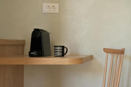 a black coffee maker sitting on a wooden shelf at Apollo Plakias in Plakias