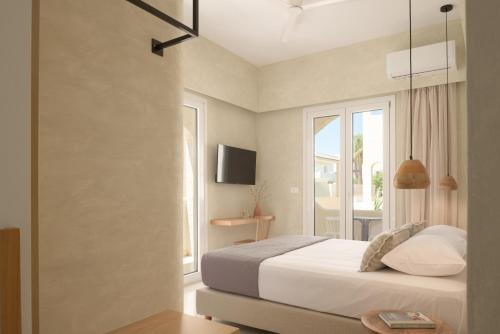 a bedroom with a white bed and a window at Apollo Plakias in Plakias
