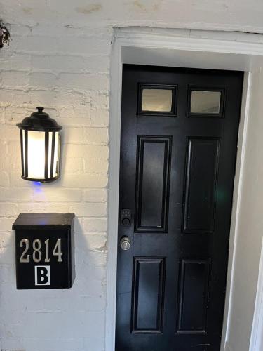 a black door with a clock next to it at Lovely Remodeled 2bdrm Basement Home in Washington, D.C.
