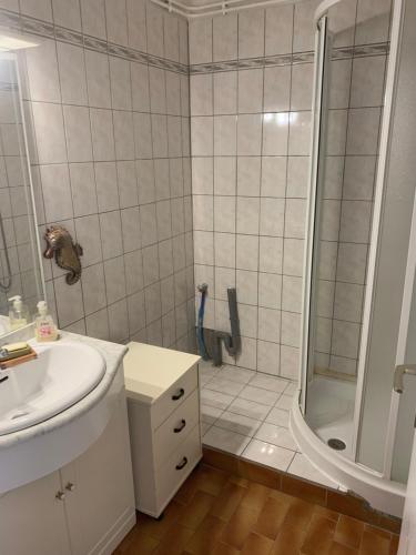 une salle de bain blanche avec une douche et un lavabo dans l'établissement T5 centre port cap d Agde et piscine, au Cap d'Agde