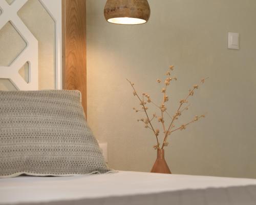 a vase with a plant sitting next to a bed at Apollo Plakias in Plakias