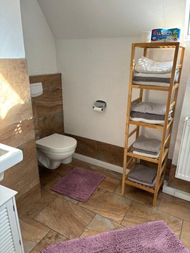 baño con aseo y estante con toallas en Ferienhaus Oliveira, en Spalt