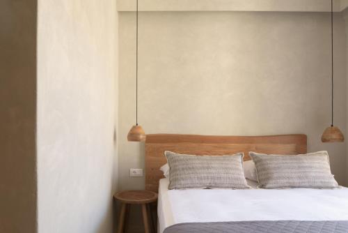 a bedroom with a bed with two pillows and two lamps at Apollo Plakias in Plakias