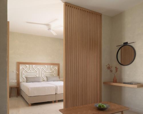 a bedroom with a bed and a table and a mirror at Apollo Plakias in Plakias