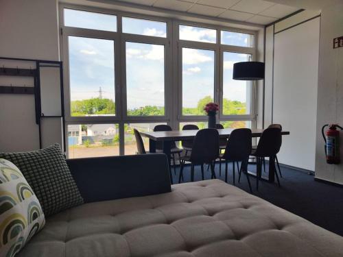ein Wohnzimmer mit einem Sofa und einem Tisch mit Stühlen in der Unterkunft Wohlfühloase Köln 3 in Köln