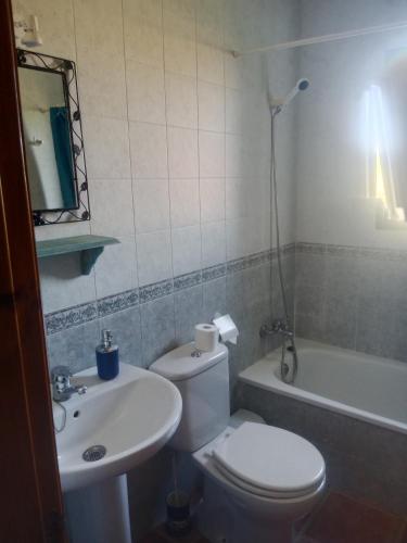 a bathroom with a toilet and a sink and a tub at Casa Rural El Cubillo in Vejer de la Frontera