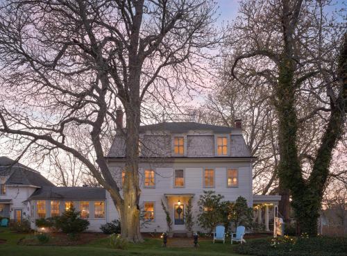 a large white house with lights on at Old Manse Inn in Brewster