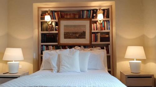 a bedroom with a bed with two lamps and bookshelves at Candelaria House Boutique in Bogotá