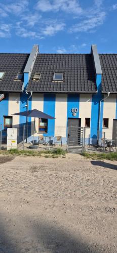 a blue and white building with a black roof at Costa Blanca Międzyzdroje - Holiday Home in Międzyzdroje