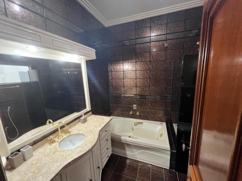 锡诺普Quarto no centro com 2 camas e hidromassagem的一间带水槽、浴缸和卫生间的浴室