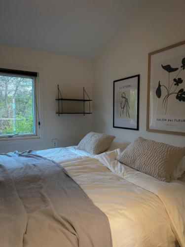 1 cama blanca en un dormitorio con ventana en Strandviks semesterboende, en Halmstad