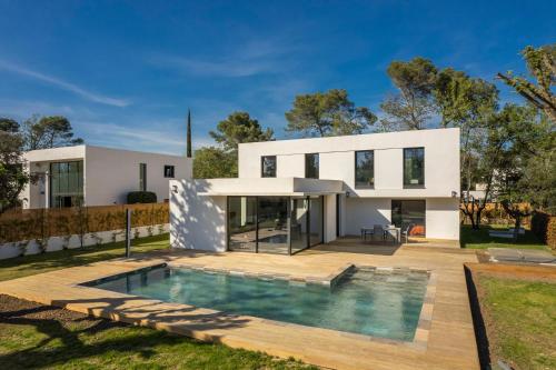 une maison avec une piscine devant dans l'établissement Villa Aksel, à Valbonne
