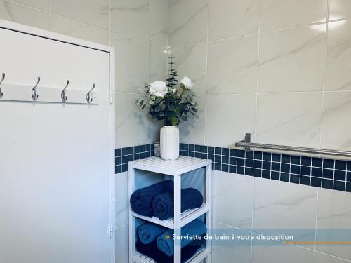 un jarrón de flores en un estante en un baño en Appartement parisien 56 m2 neuf, moderne avec 2 chambres, 4 lits, parking gratuit, 15min de Paris et 13 min aéroport Orly en Vitry-sur-Seine