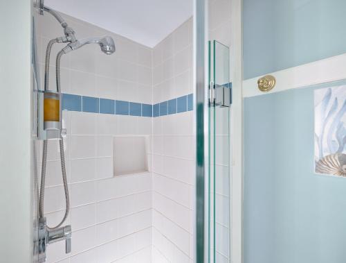 a bathroom with a shower with blue and white tiles at Old Manse Inn in Brewster