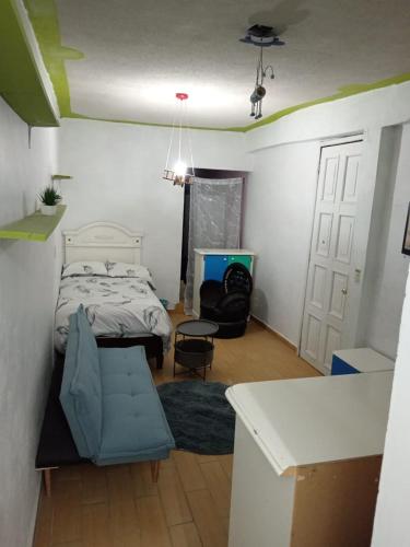 um pequeno quarto com uma cama e uma mesa em MI PORTON GRIS em Santa Cruz Tecamac