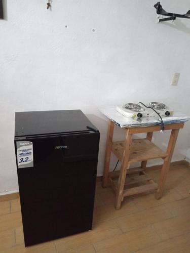 uma mesa e um pequeno frigorífico ao lado de uma mesa em MI PORTON GRIS em Santa Cruz Tecamac