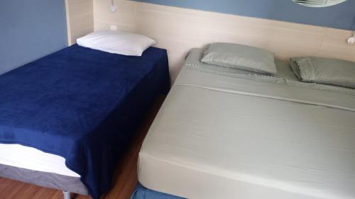 Cette petite chambre comprend 2 lits avec des draps bleus. dans l'établissement Flat no Mercure Navegantes, à Récife