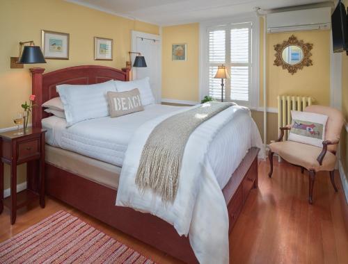 a bedroom with a large bed and a chair at Old Manse Inn in Brewster