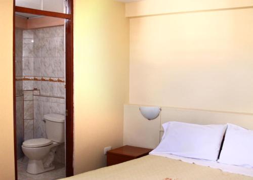 1 dormitorio con cama y aseo en Hostal Lucerito en Cusco