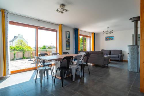 une salle à manger avec une table, des chaises et un canapé dans l'établissement Cocon vert proche mer, à Plouhinec