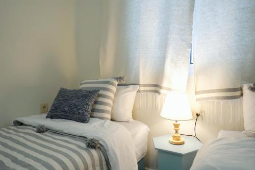 ein Schlafzimmer mit 2 Betten und einer Lampe auf einem Tisch in der Unterkunft Dar Badr in Tangier