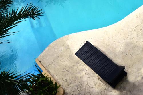 a black object sitting next to a swimming pool at Hotel Beach Energy 5th Av in Playa del Carmen