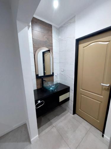 a bathroom with a sink and a mirror and a door at Complejo calle Cordoba Departamento 2 in General Roca