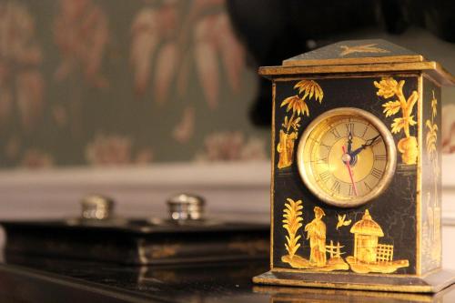 a small clock sitting on top of a table at Hôtel Littéraire Gustave Flaubert, BW Signature Collection in Rouen