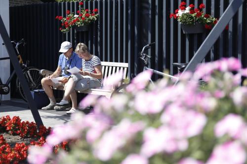 two women sitting on a bench next to flowers at Maashof in Venlo