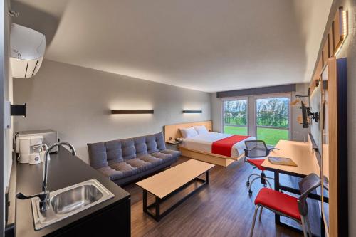 塞拉亞的住宿－City Express by Marriott Celaya Galerias，客厅配有沙发和一张位于房间的床