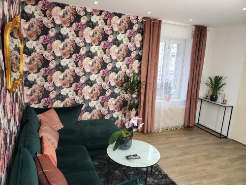 a living room with a green couch and a floral wall at Mirka & Franck AIRCON Apartment Chic 4" Stars Parking Free, Garage & Wine with Avantages Pack in Colmar