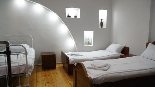 Zimmer mit 2 Betten und einem Spiegel in der Unterkunft Eleven Guest House in Kutaissi