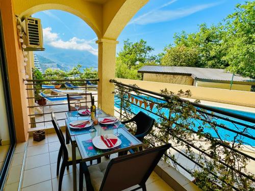 a table on a balcony with a view of the water at Apartment "Gluecks-Griff" inside "Becici Sunset Apartments" in Budva