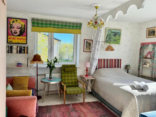a bedroom with a bed and a chair at LITTLE LONDON boutique apartment with Netflix, top location in Old Town in Narva