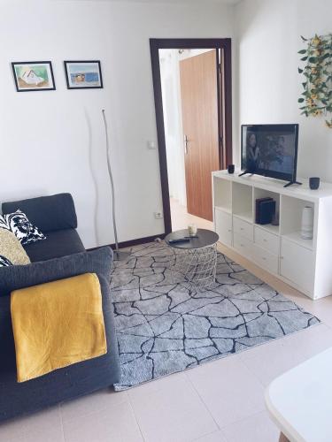 a living room with a couch and a tv at Casinha do Lagar in Nadadouro