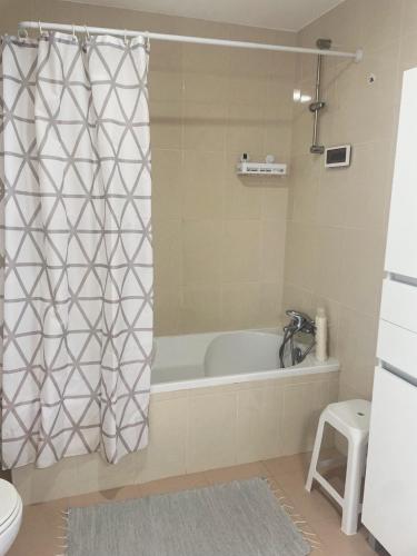 a bathroom with a tub and a shower curtain at Casinha do Lagar in Nadadouro