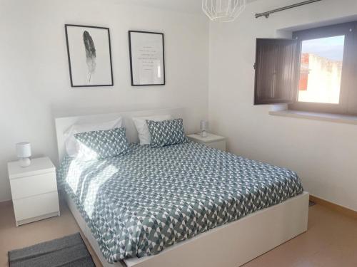 a bedroom with a bed and a window at Casinha do Lagar in Nadadouro