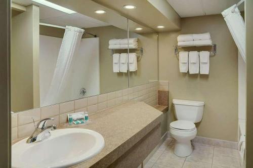 y baño con lavabo, aseo y espejo. en Radisson Hotel Fort St John, en Fort Saint John