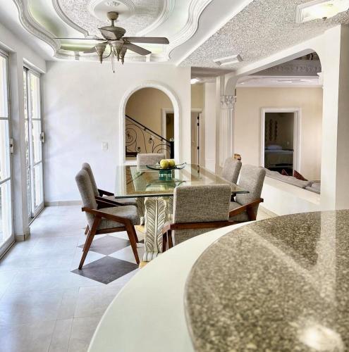 a dining room with a glass table and chairs at Casa Arcángel SM in Cruz de Huanacaxtle