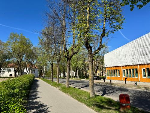 an empty sidewalk next to a building with trees at LITTLE LONDON boutique apartment with Netflix, top location in Old Town in Narva