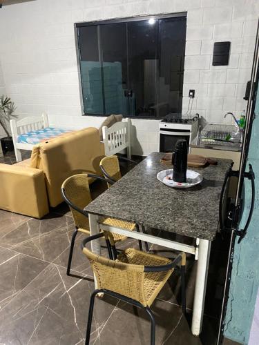 eine Küche mit einem Tisch und Stühlen sowie ein Wohnzimmer in der Unterkunft Espaço Mattigor in Caçapava