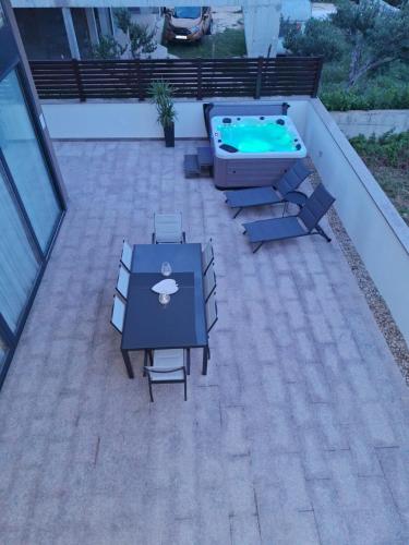 a patio with a table and a swimming pool at Luxury Villa Bueno in Kaštela