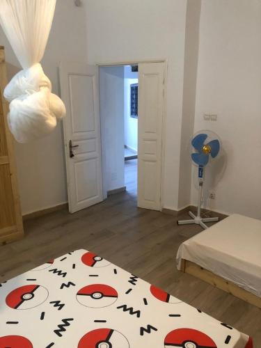 a bedroom with a bed with a blanket with a face on it at Chambre triple - SDB privée & Cuisine équipée & Breakfast in Saint-Louis