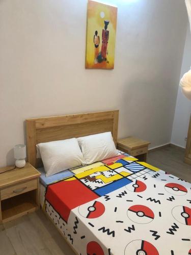 a bedroom with a bed with a colorful comforter at Chambre triple - SDB privée & Cuisine équipée & Breakfast in Saint-Louis